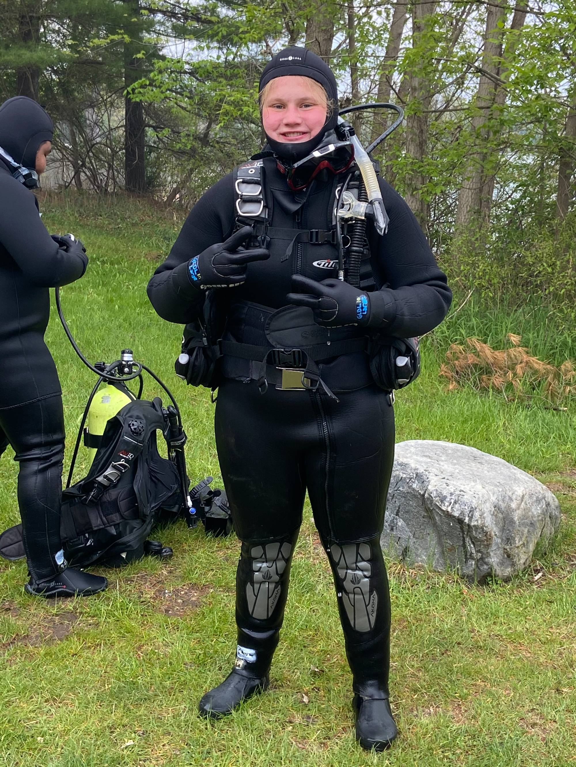 Scuba student throws up a peace sign before diving